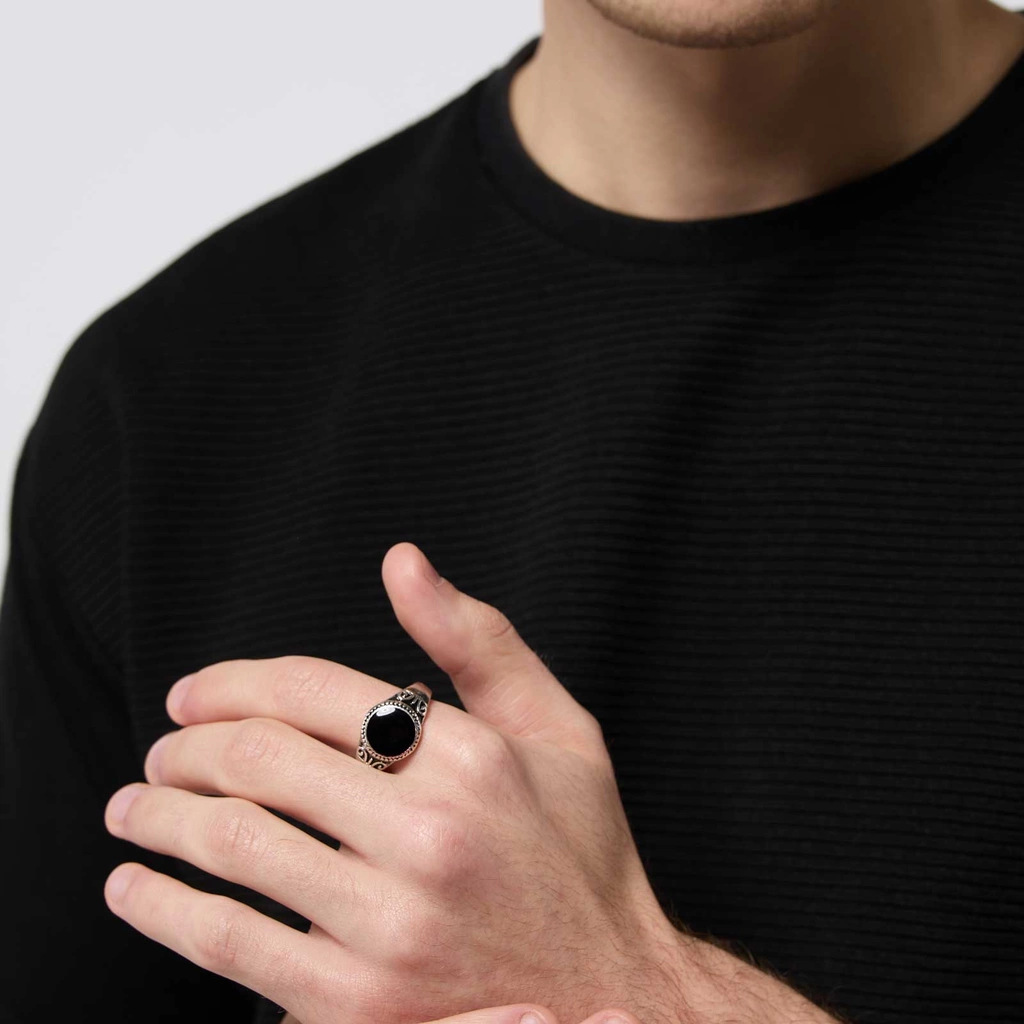 Silverfärgad ring med svart yta och mönster