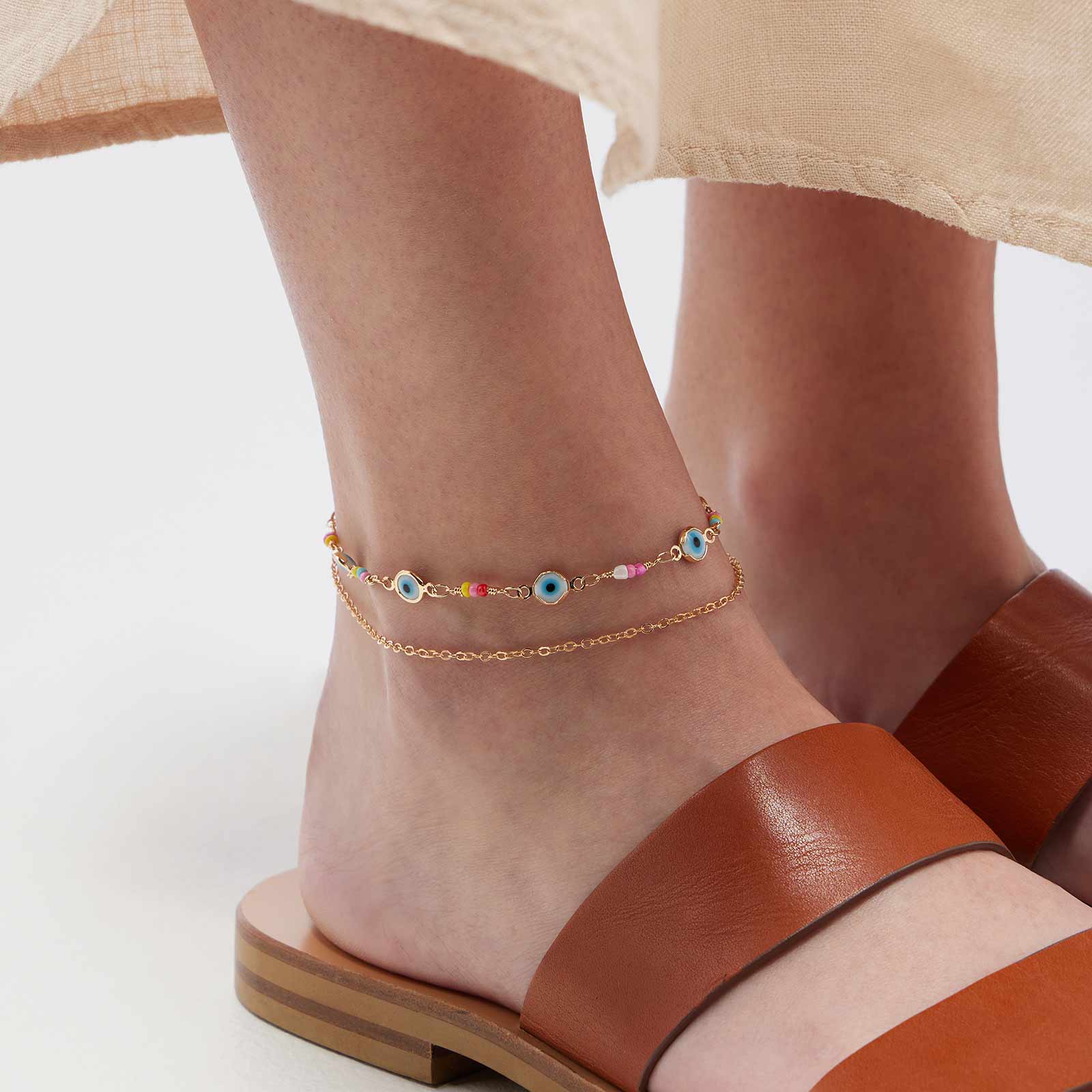 Guldfärgad fotlänk - plastpärlor och blå ögonstenar