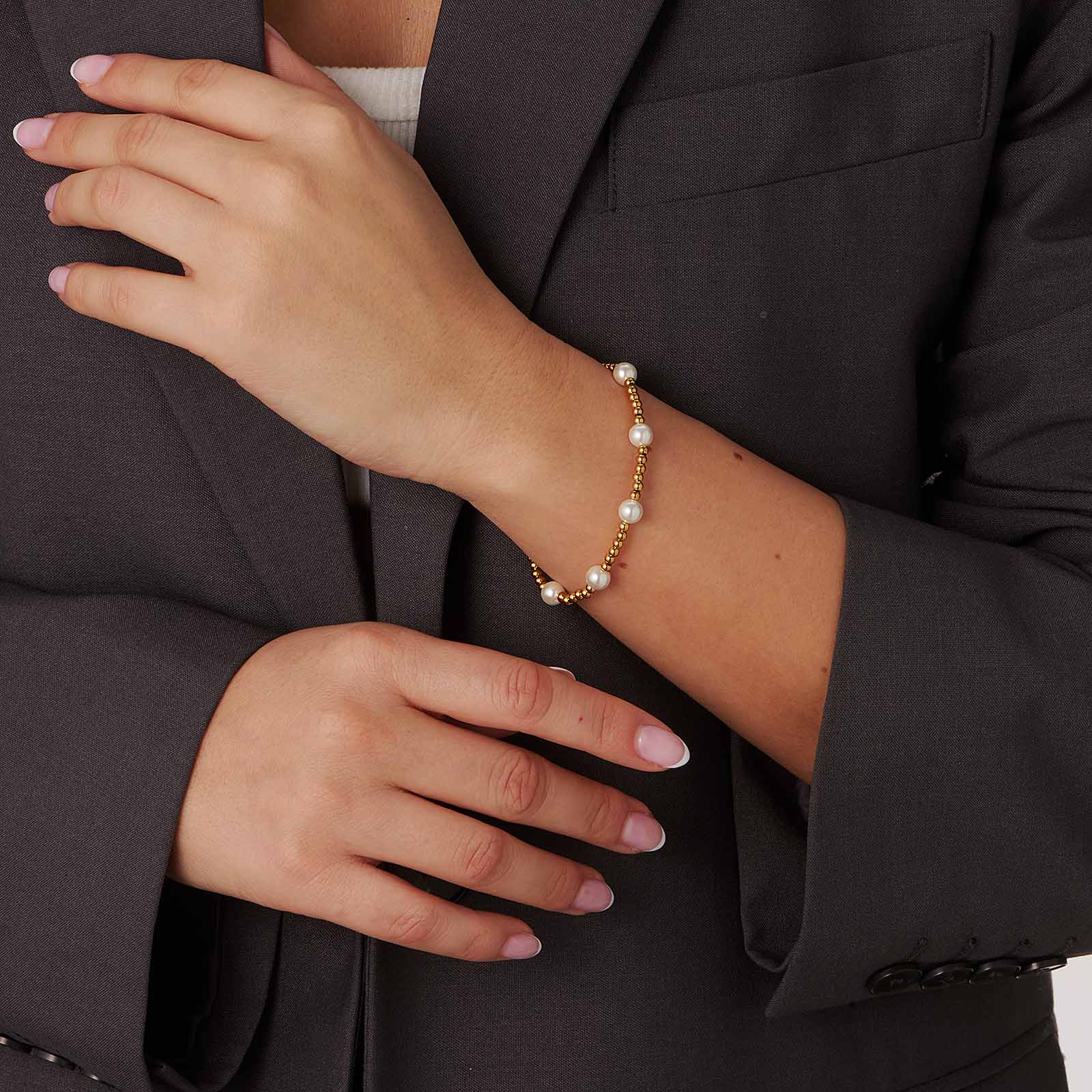 Armband i guldpläterat stål - elastiskt med kulor och vita skalpärlor